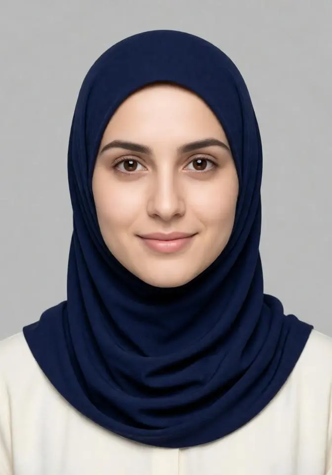 Young woman wearing a navy blue hijab and light blouse, front-facing passport photo on a light gray background.