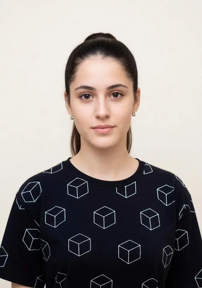UK passport photo of an adult person looking directly at the camera with a neutral expression and a light cream background.