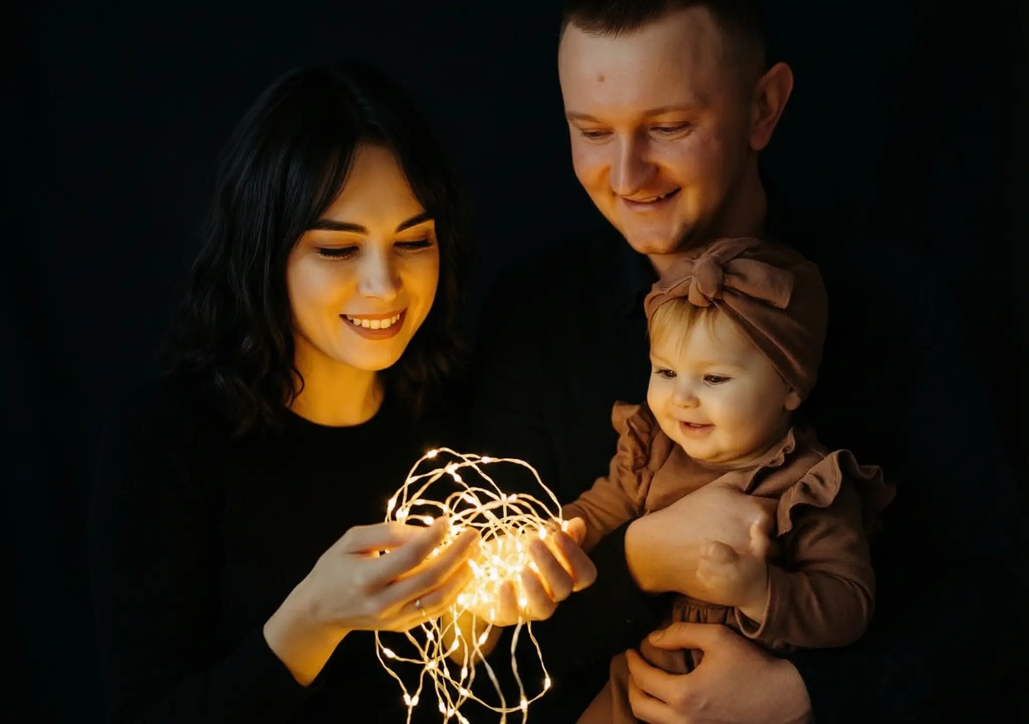 cinematic family portrait of three family members in a dark setting