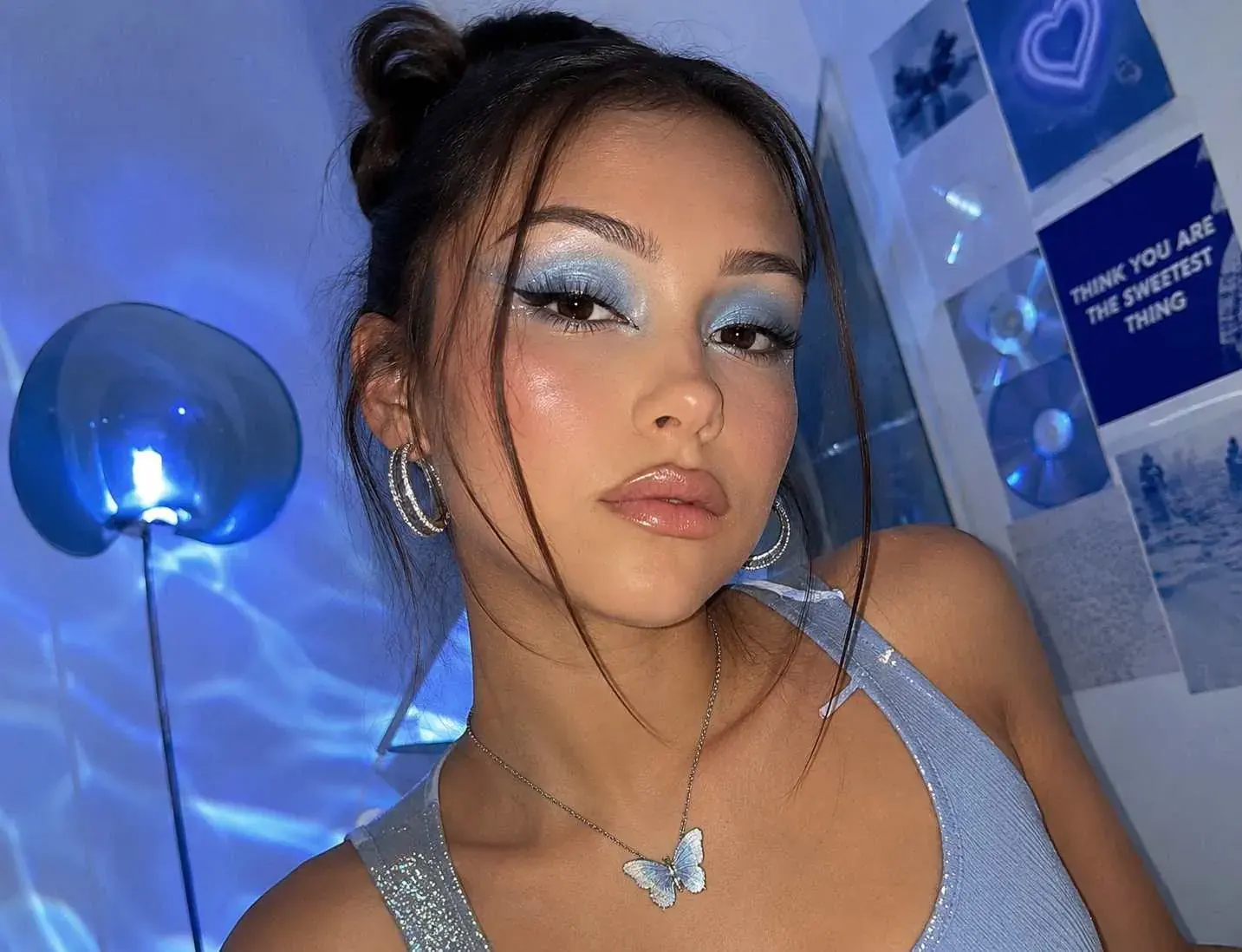 Y2K-inspired makeup with icy blue eyeshadow and shimmer.