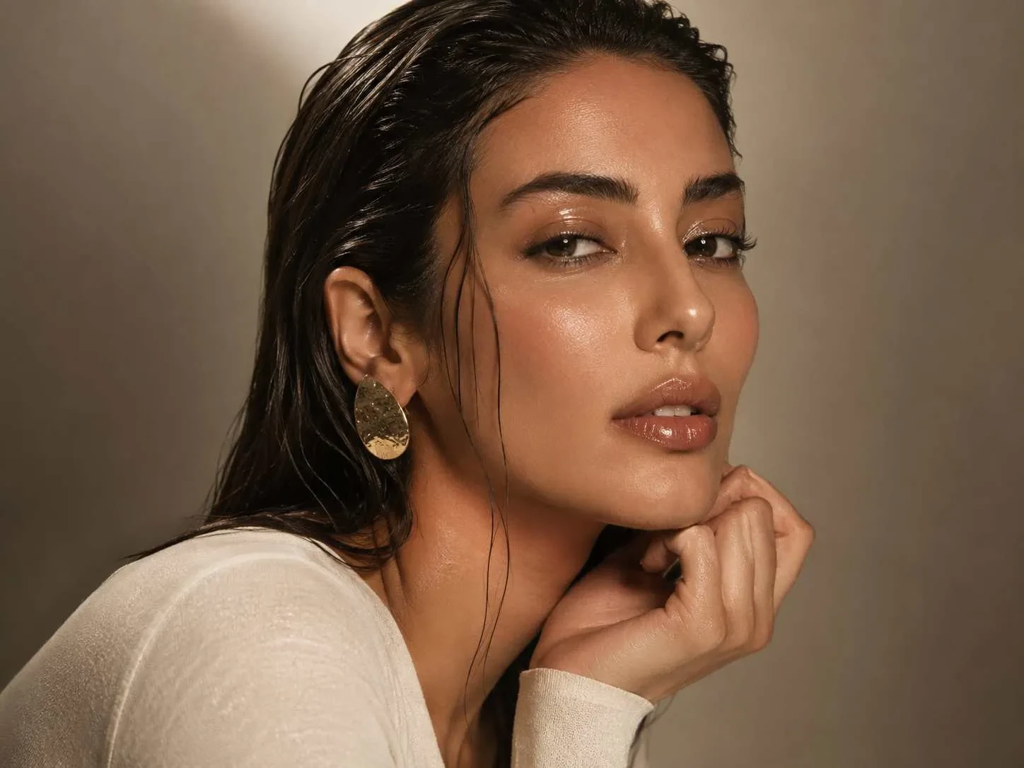 Editorial wet-look beauty makeup with glossy radiant skin.