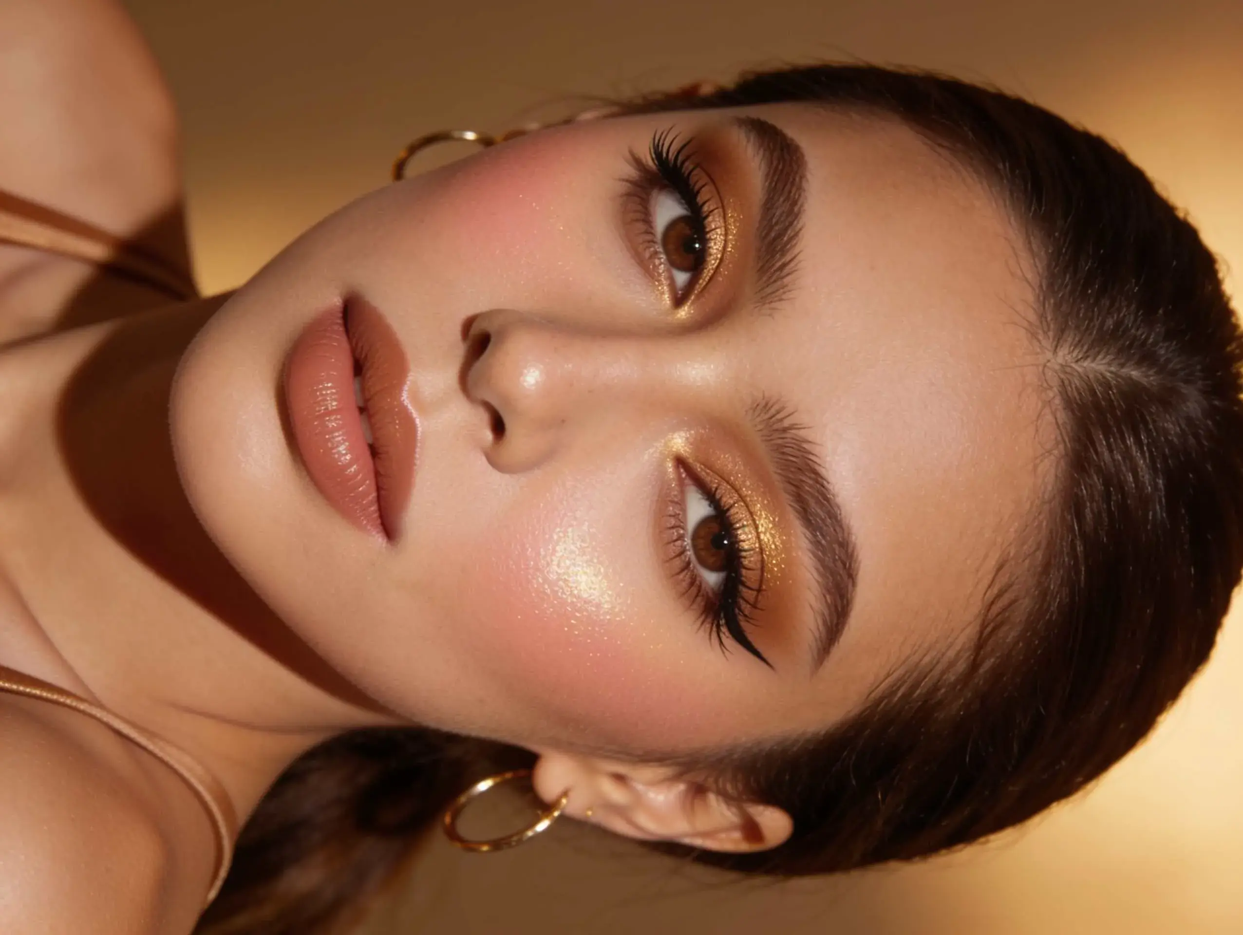 Soft glam makeup with warm neutral tones and satin skin.