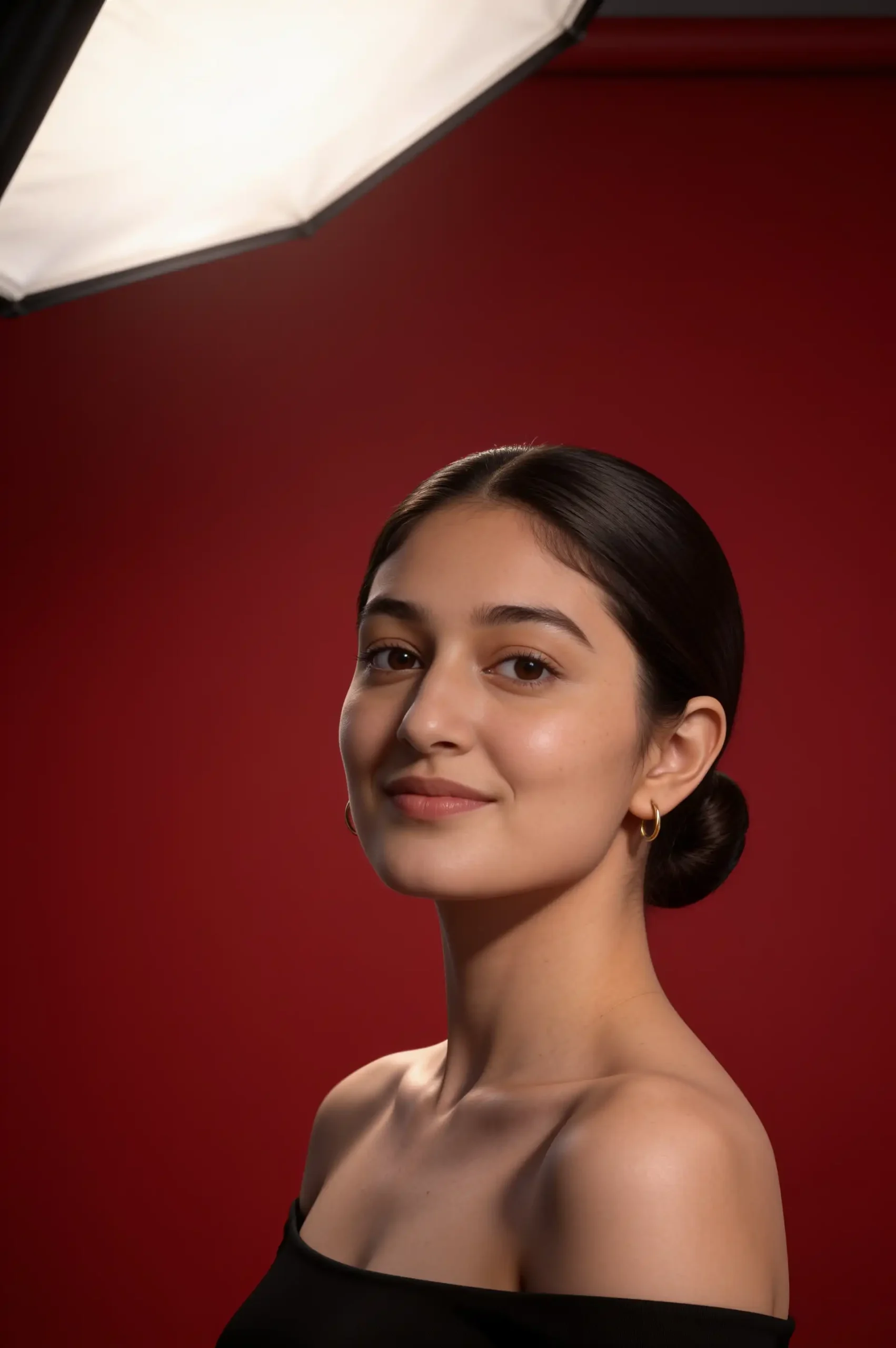 Woman posing in a black top against a smooth scarlet-red studio background.