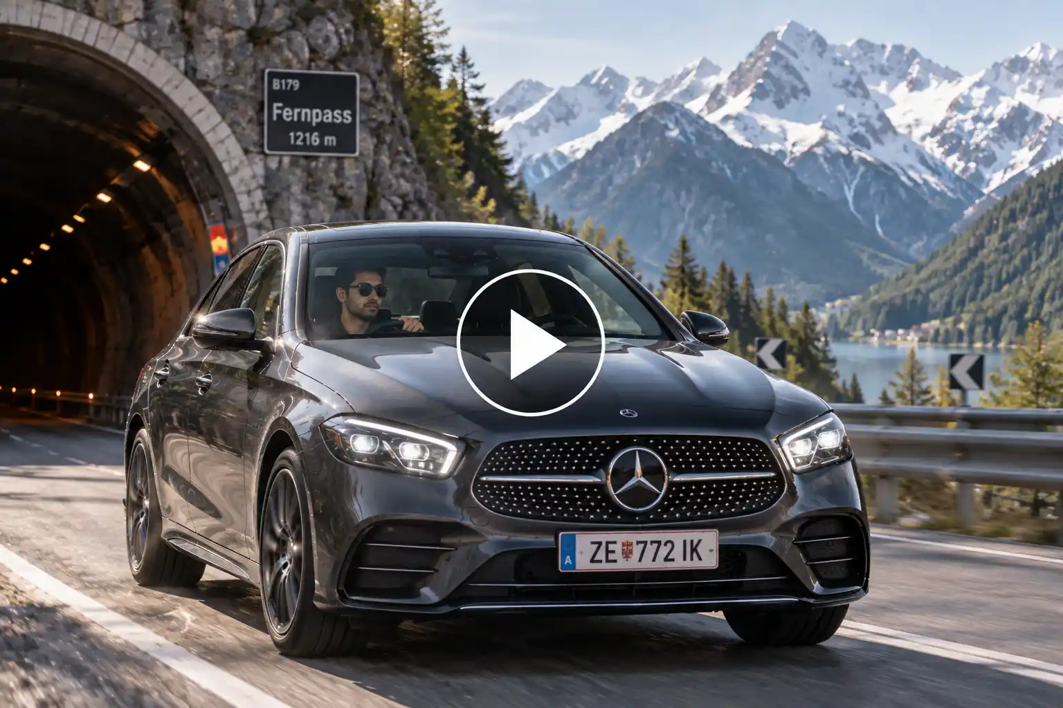 Man driving a Mercedes through an alpine tunnel with snowy Austrian mountains in the background.