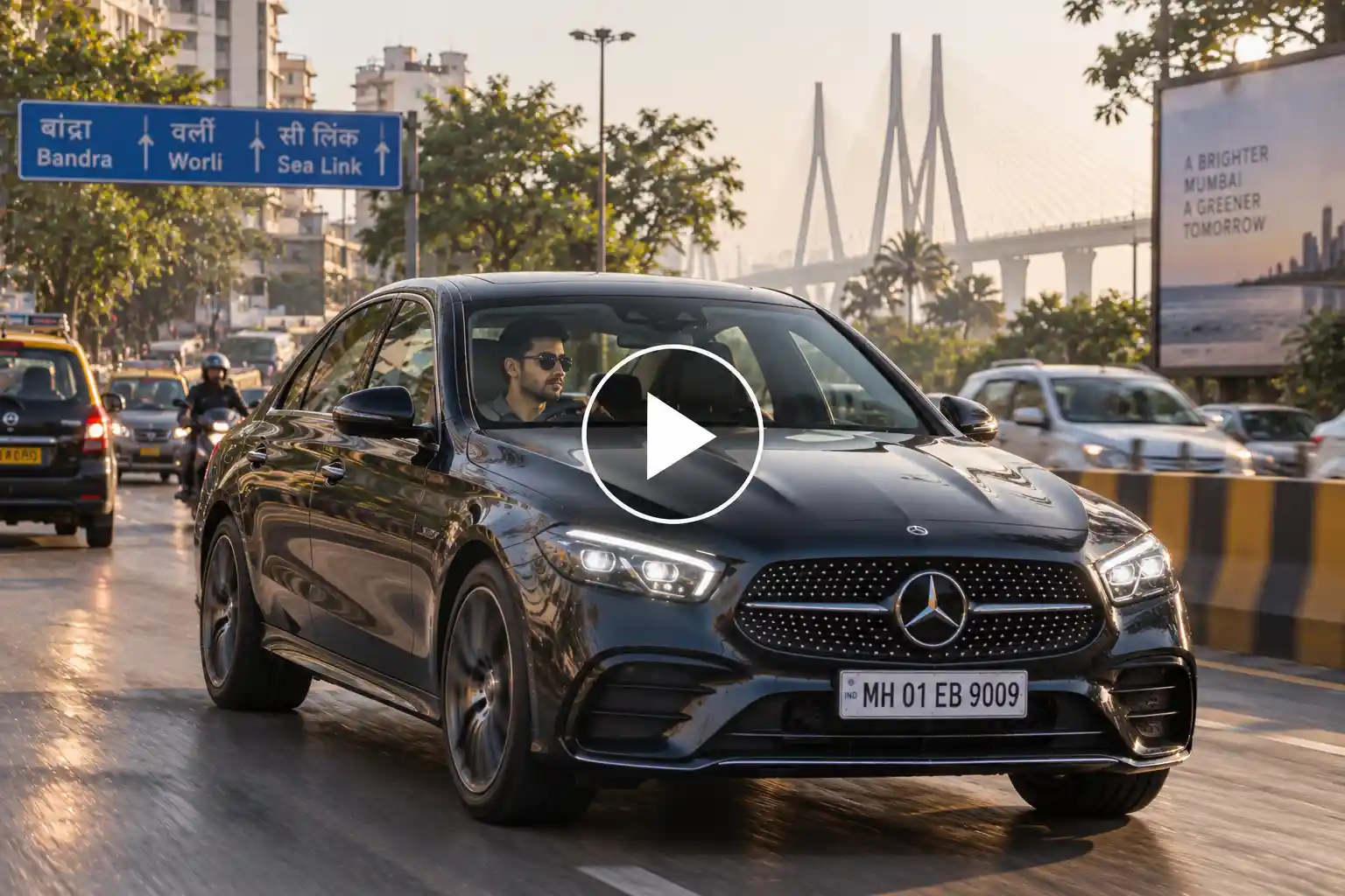 Man driving a Mercedes through Mumbai at dawn with city traffic and buildings in the background.