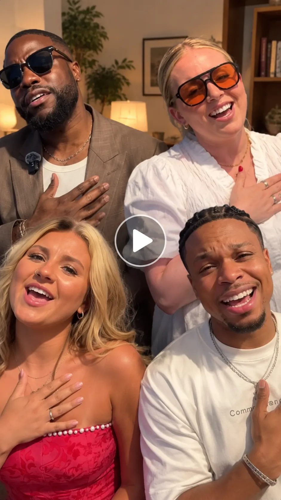 Two men and two women lip-syncing to Justin Bieber’s Baby song with emotional expressions and hands over their hearts, featuring a transparent play button.